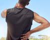 Man stood outside holding neck in pain.