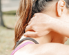 Woman holding neck in pain from a side shot angle
