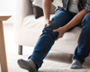 Zoomed in picture of man holding his knee in pain.