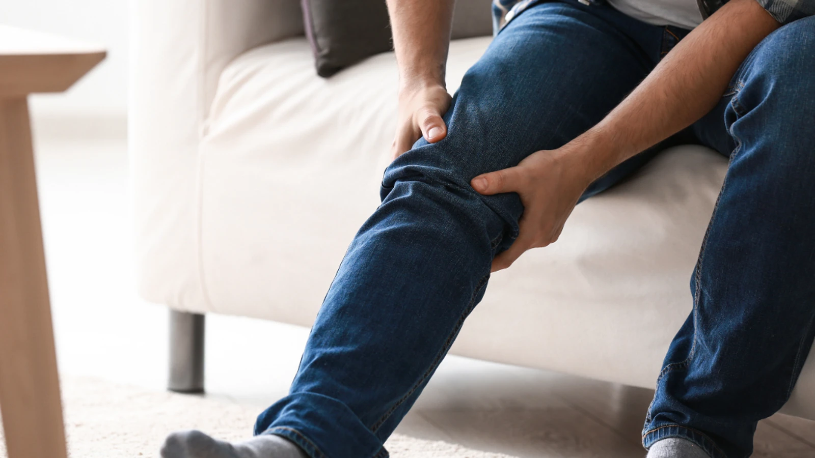 Zoomed in picture of man holding his knee in pain.