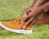 woman wearing orange trainers with ankle pain