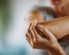 Close up woman holding elbow in pain.