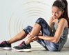 Woman in activewear sat down holding her leg in pain.