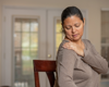 woman holding shoulder in pain.