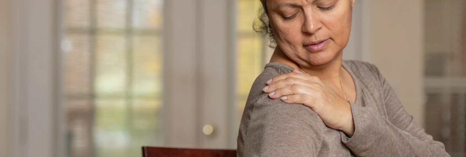 woman holding shoulder in pain.