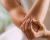 Zoomed in angle of woman holding her elbow in pain.