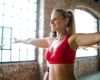 Woman wearing red top stretching