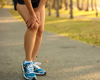 Woman on a run holding her knee in pain.