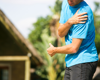 man in running wear holding shoulder