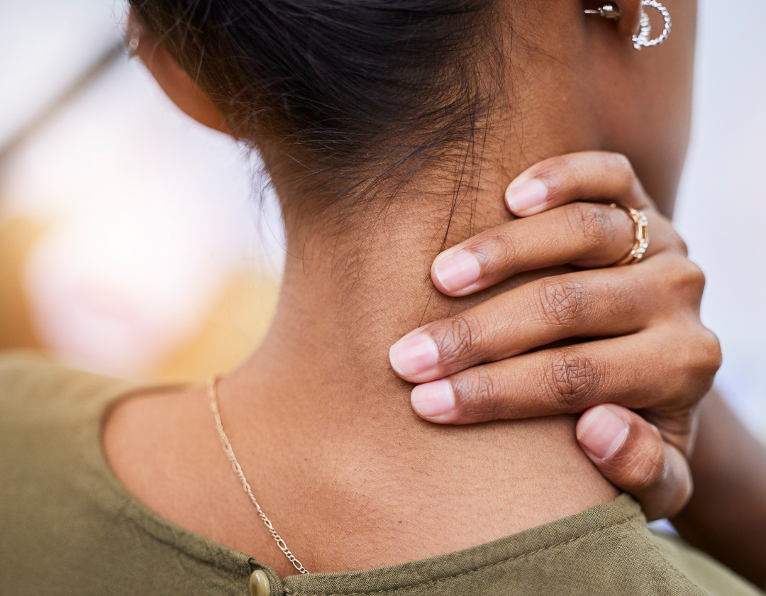 Close up from behind of woman holding her neck in pain.