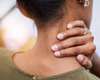 Close up from behind of woman holding her neck in pain.
