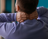 Man holding neck with both hands